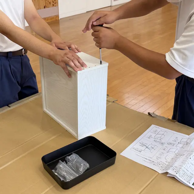 生徒が家具を組み立てる