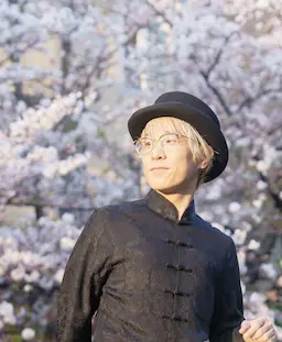 桜の前で微笑む男性